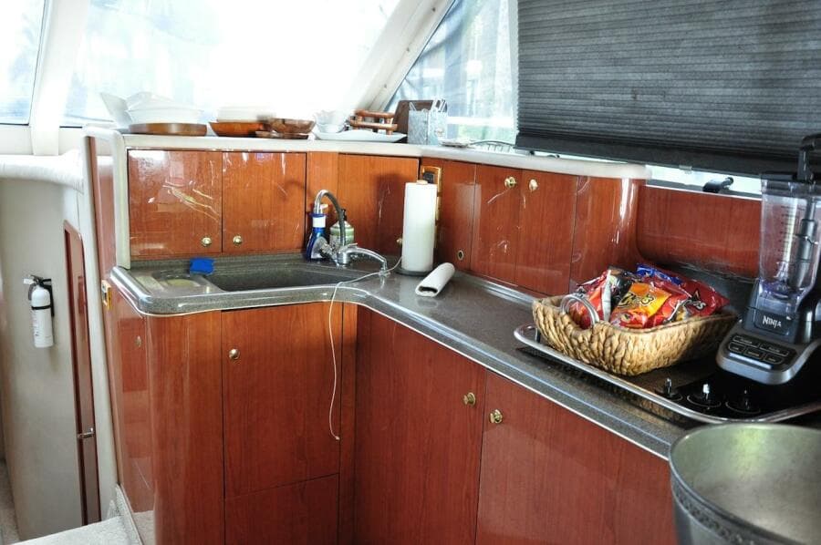 1998 Sea Ray 480 Sedan Bridge kitchen with wooden cabinets and countertop appliances.