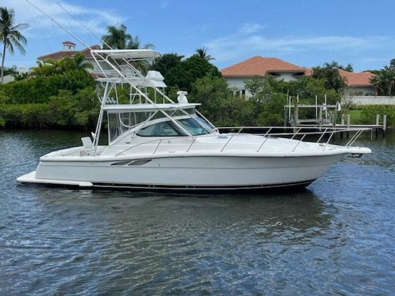 2003 Tiara Yachts 3800 Open boat on calm water, surrounded by lush greenery.