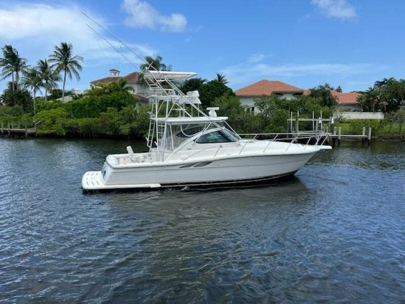 2003 Tiara Yachts 3800 Open cruising on a scenic waterway with palm trees.