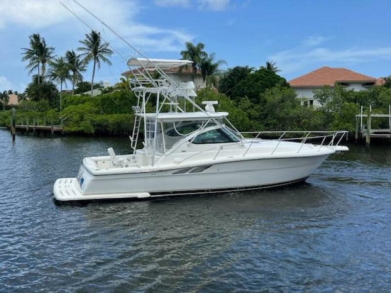2003 Tiara Yachts 3800 Open cruising on a scenic waterway with palm trees.