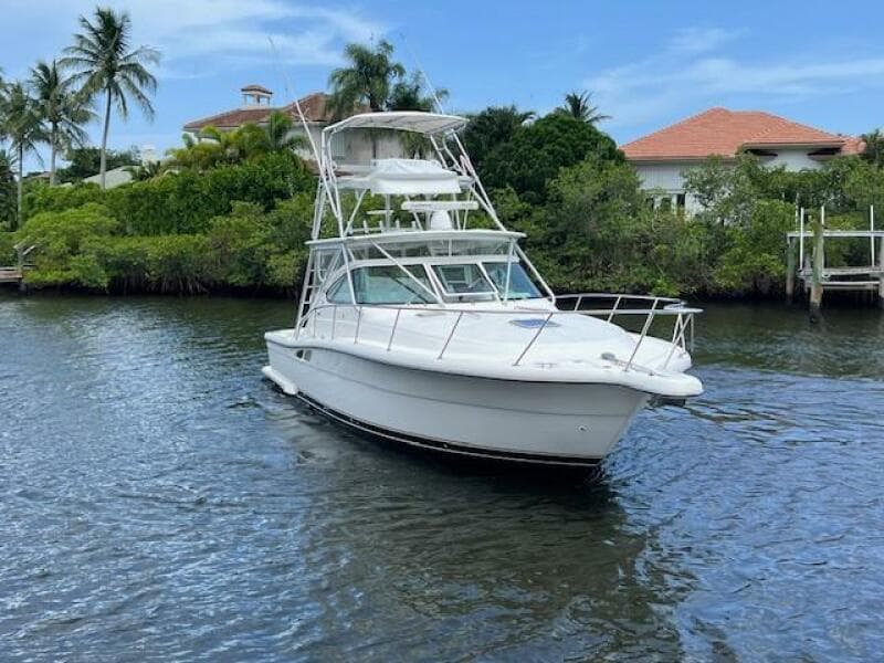 2003 Tiara Yachts 3800 Open cruising on a scenic waterway with lush greenery.