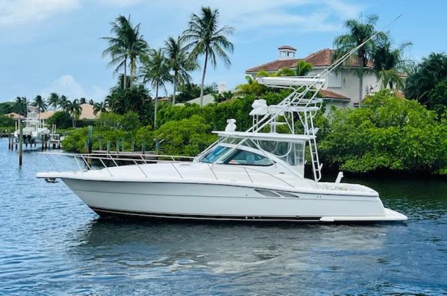 2003 Tiara Yachts 3800 Open cruising on a scenic waterway with palm trees.