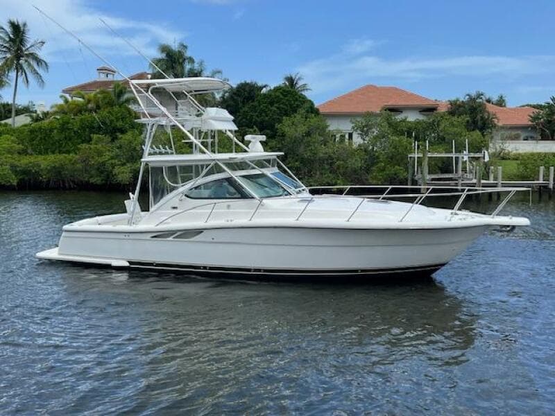 2003 Tiara Yachts 3800 Open boat on calm water, surrounded by lush greenery.