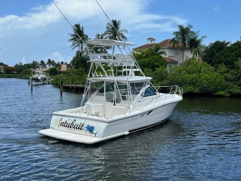 2003 Tiara Yachts 3800 Open boat on a scenic waterway with palm trees.