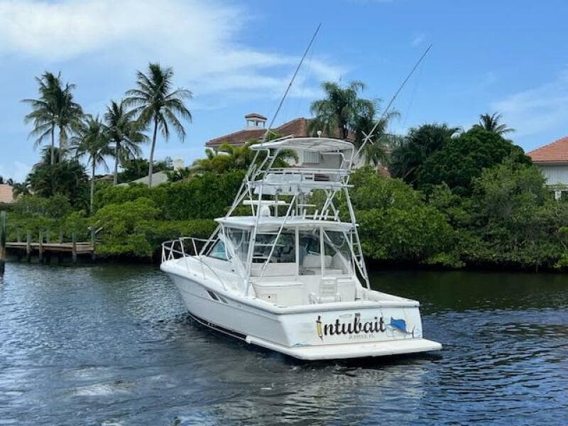 2003 Tiara Yachts 3800 Open cruising on a tropical waterway with palm trees.