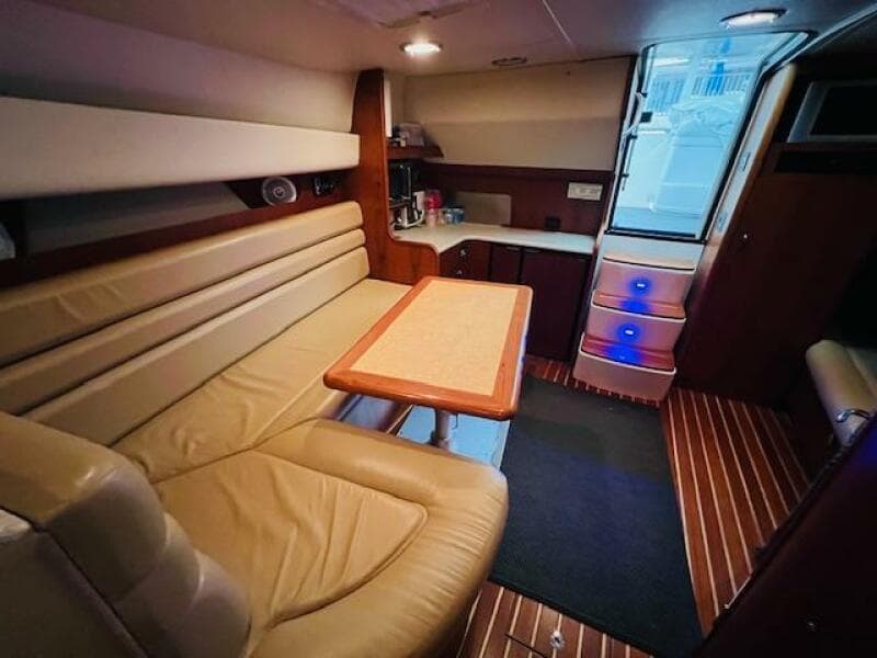 Interior of 2003 Tiara Yachts 3800 Open with leather seating and wooden flooring.