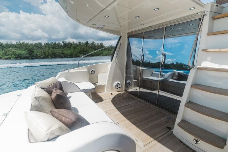 Luxurious 2015 Beneteau Monte Carlo 5 yacht deck with seating, stairs, and scenic water view.