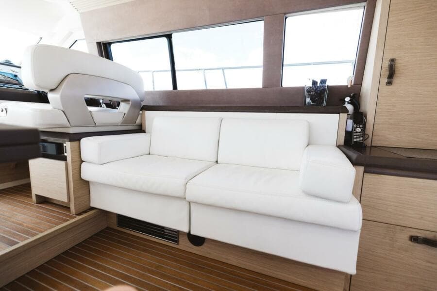 Luxurious interior of 2015 Beneteau Monte Carlo 5 yacht with white sofa and wooden flooring.