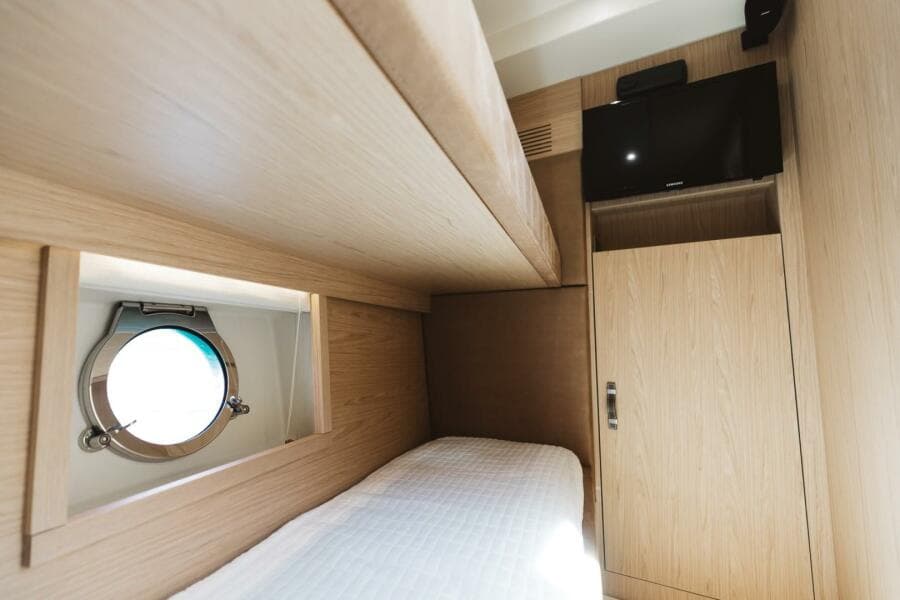 Interior cabin of 2015 Beneteau Monte Carlo 5 yacht with porthole and TV.