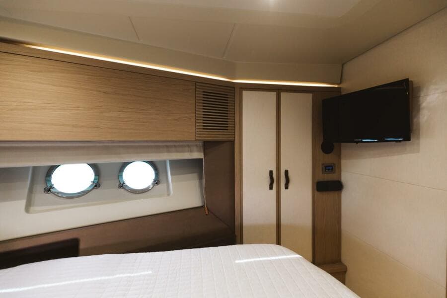 Luxurious cabin interior of 2015 Beneteau Monte Carlo 5 yacht with portholes and TV.