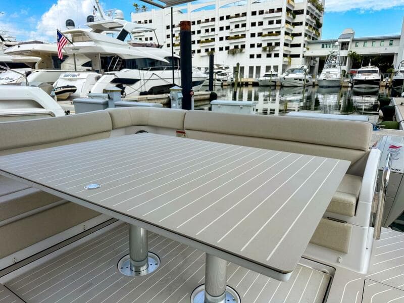 2023 Azimut Verve 47 yacht with elegant outdoor seating and table at marina.