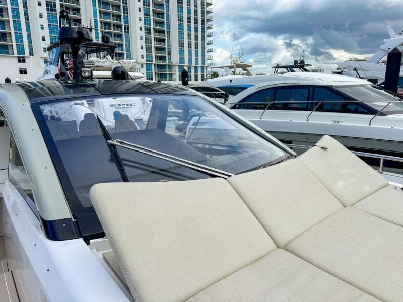 2023 Azimut Verve 47 yacht with sunbathing area, docked near modern buildings.