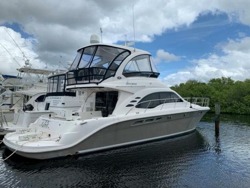 2006 Sea Ray 52 Sedan Bridge yacht docked in a marina.