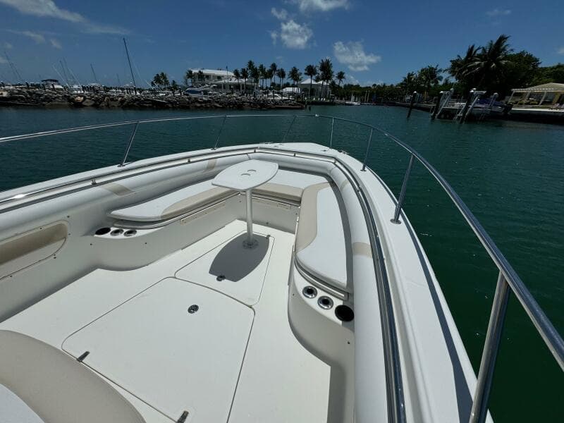 2008 Boston Whaler 320 Outrage boat with spacious seating and table, docked in a marina.