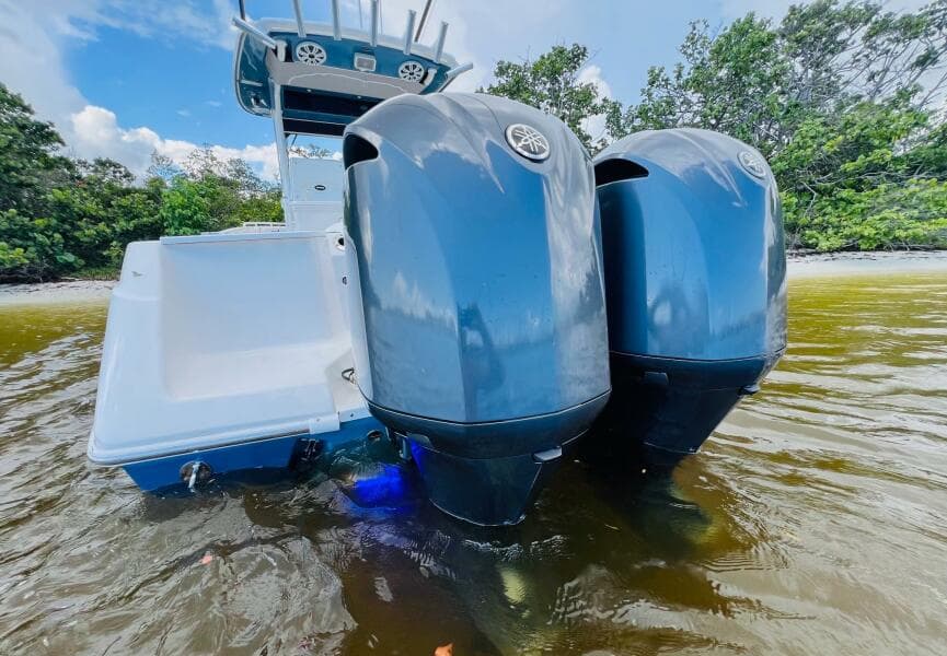2012 Everglades 295 Center Console boat with dual outboard motors in shallow water.