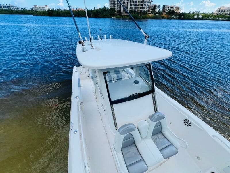 2012 Everglades 295 Center Console boat on calm water, featuring sleek design and fishing rods.