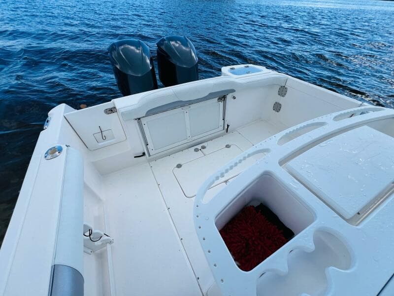 2012 Everglades 295 Center Console boat on water, featuring spacious deck and dual engines.