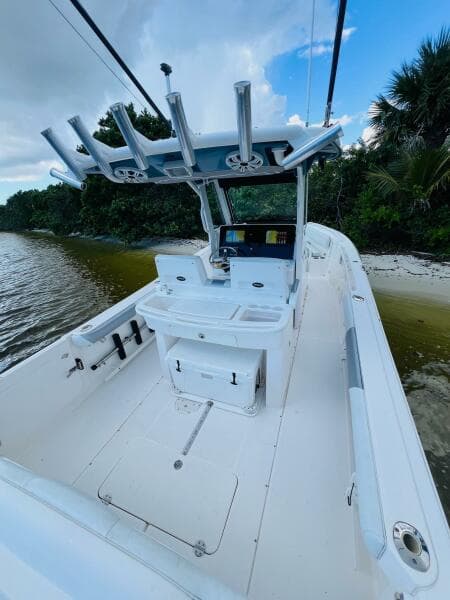 2012 Everglades 295 Center Console boat on a serene shoreline.