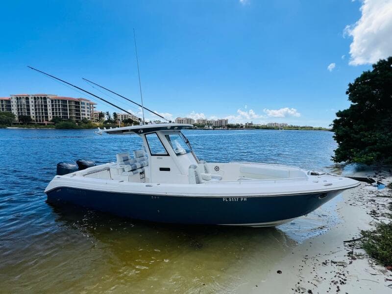 2012 Everglades 295 Center Console boat on sandy shore, clear blue sky.