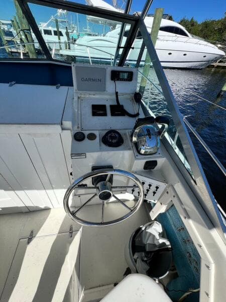 1988 Grady-White 25 SAILFISH boat cockpit with steering wheel and Garmin equipment.