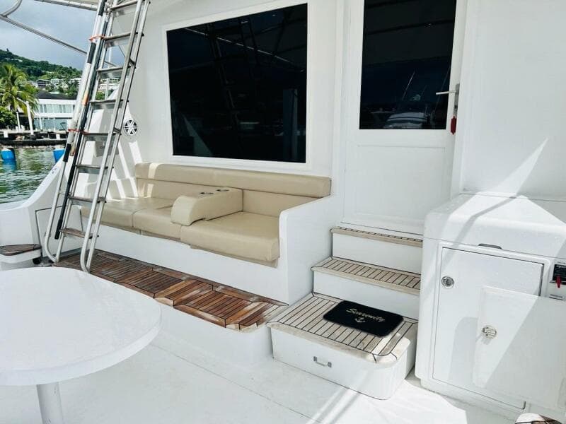 1988 Bertram 54' yacht deck with seating, ladder, and steps in a marina setting.