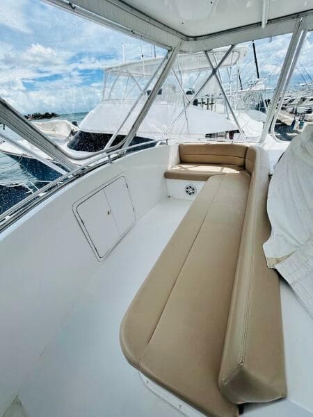 1988 Bertram 54' yacht interior with beige seating and marina view.