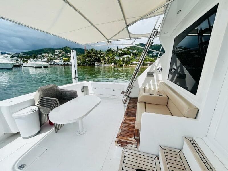 1988 Bertram 54' yacht deck with seating, table, and scenic marina view.