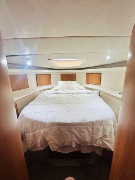 Luxurious bedroom interior of 1988 Bertram 54' yacht with cozy bedding.