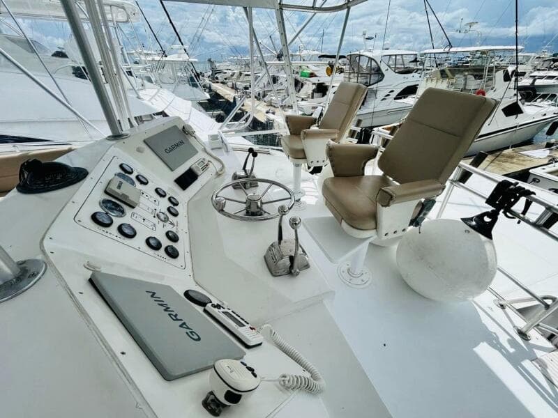 Cockpit of 1988 Bertram 54' yacht with Garmin navigation, docked at marina.