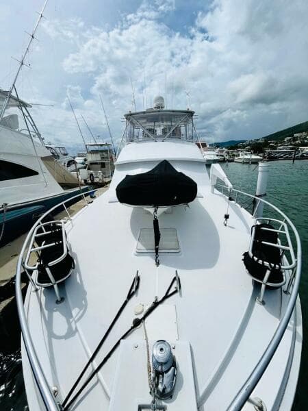 1988 Bertram 54' yacht docked at marina under cloudy sky.
