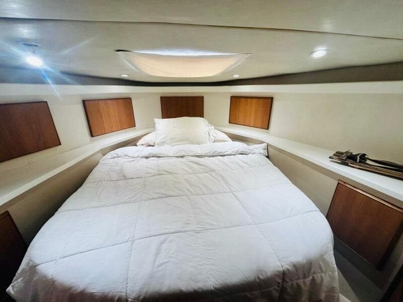 Luxurious bedroom interior of 1988 Bertram 54' yacht with cozy bedding.