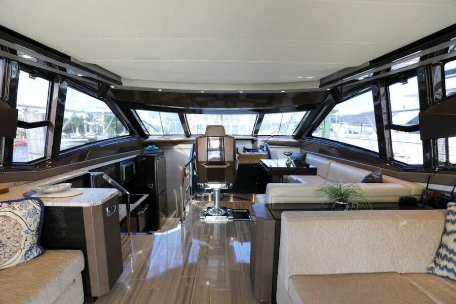 Luxurious interior of 2016 Marquis 660 Sport Yacht with modern seating and panoramic windows.