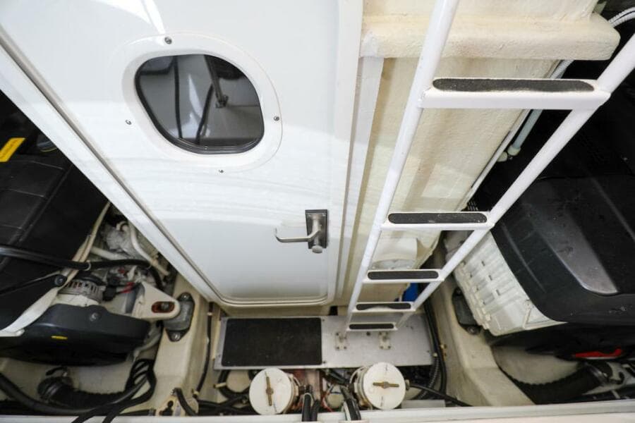 Engine room of 2016 Marquis 660 Sport Yacht with ladder and equipment.