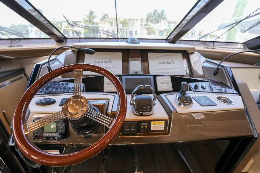 Cockpit of 2016 Marquis 660 Sport Yacht with Garmin navigation system and wooden steering wheel.