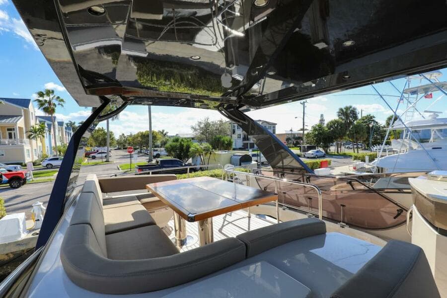 Luxurious 2016 Marquis 660 Sport Yacht with spacious outdoor seating and dining area.