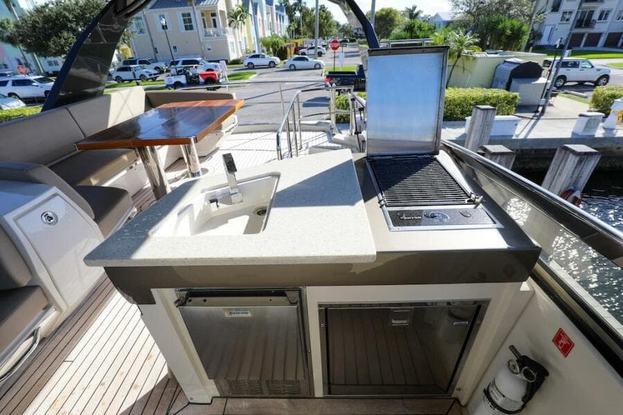 Outdoor kitchen on 2016 Marquis 660 Sport Yacht with sink and grill.