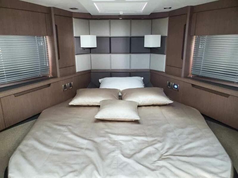 Luxurious bedroom in 2020 Galeon 500 Fly yacht with modern decor and ample natural light.