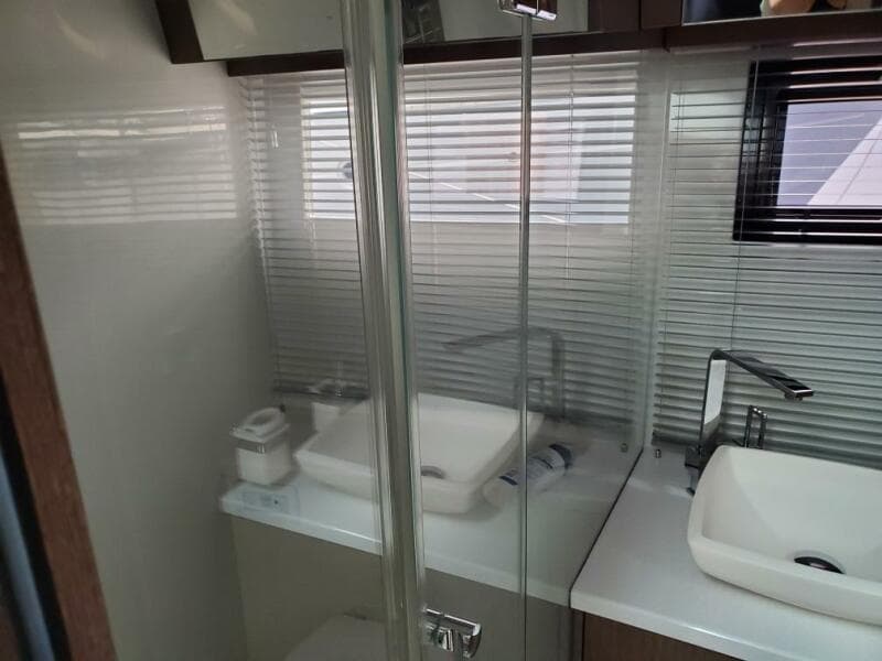 Modern bathroom in 2020 Galeon 500 Fly yacht with dual sinks and glass shower.
