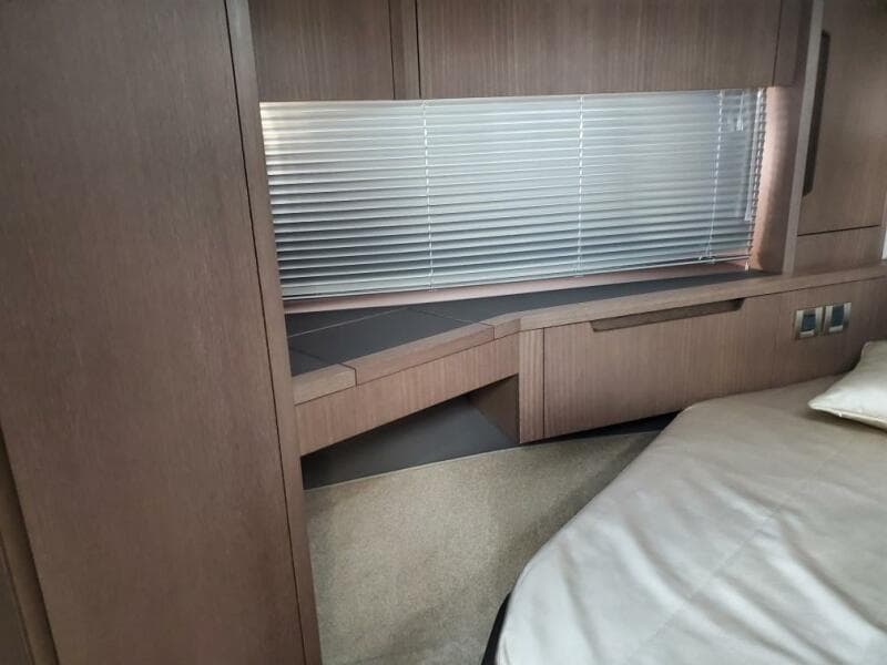 Interior cabin of 2020 Galeon 500 Fly yacht with wooden furnishings and blinds.