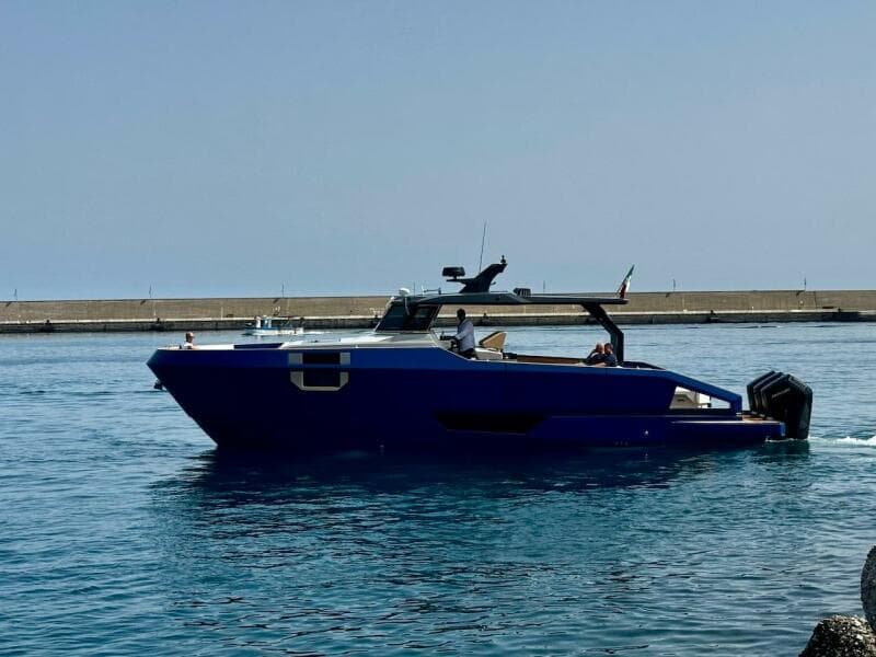 2025 Aicon Audace 50 yacht cruising in calm waters near a pier.
