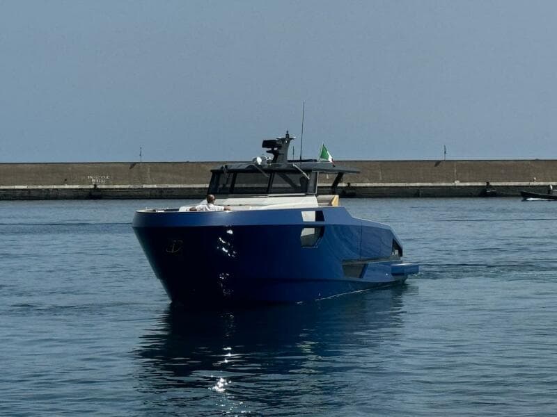 2025 Aicon Audace 50 yacht in a harbor, featuring sleek blue design.