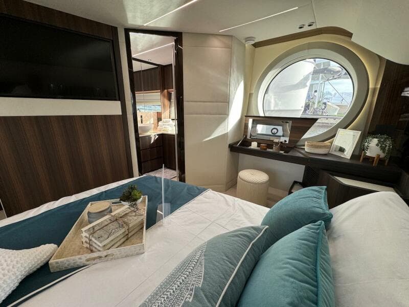 Luxurious interior of 2024 Aicon 66 Vivere yacht with elegant bedroom and scenic window view.