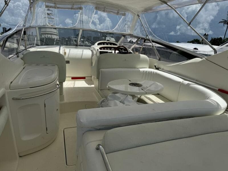 2003 Cranchi Endurance 39 yacht interior with white seating and helm, under a clear canopy.
