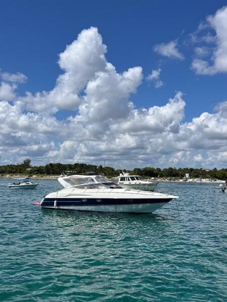 2003 Cranchi Endurance 39 yacht on clear blue water under a cloudy sky.