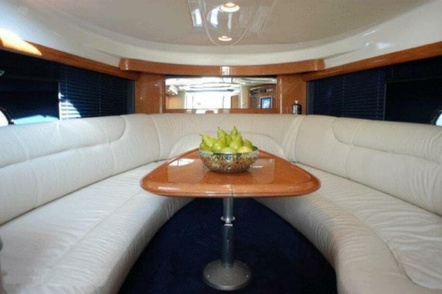 Interior of 2003 Cranchi Endurance 39 yacht with white seating and wooden table.