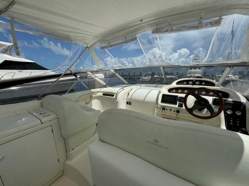 2003 Cranchi Endurance 39 yacht interior with helm, white seating, and clear canopy.