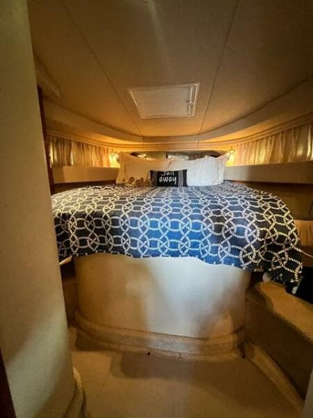 Interior cabin of 2003 Sea Ray 380 Sundancer with cozy bed and nautical decor.