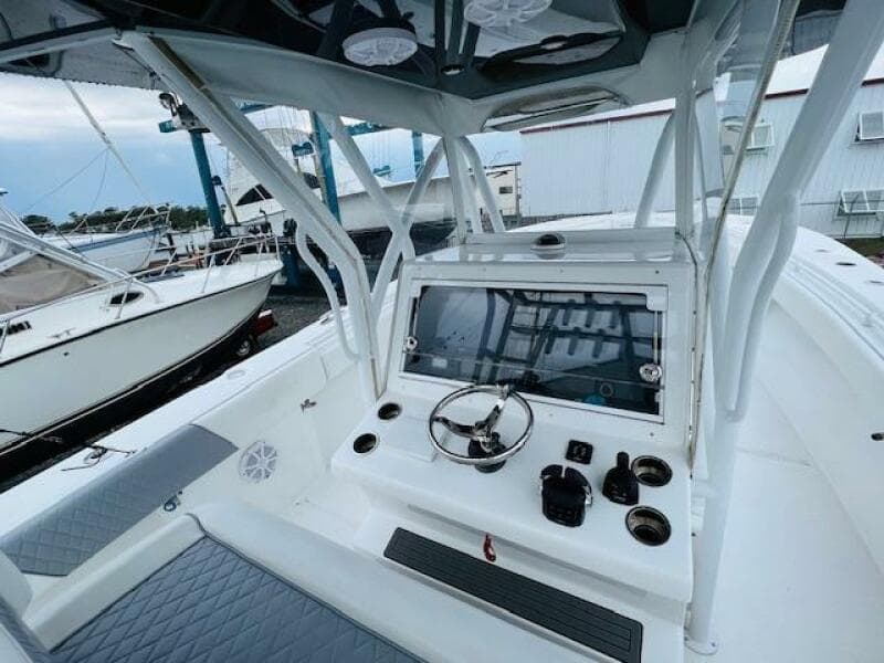 2020 SeaHunter 39 Tournament boat cockpit with steering wheel and controls, docked near other boats.