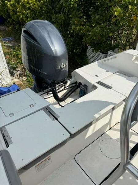 2016 Release 208 RX boat with Yamaha 150 outboard motor, docked near greenery.