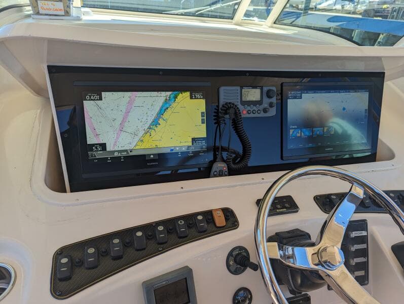 Control panel of 2012 Grady-White Canyon 366 boat with navigation screens and steering wheel.